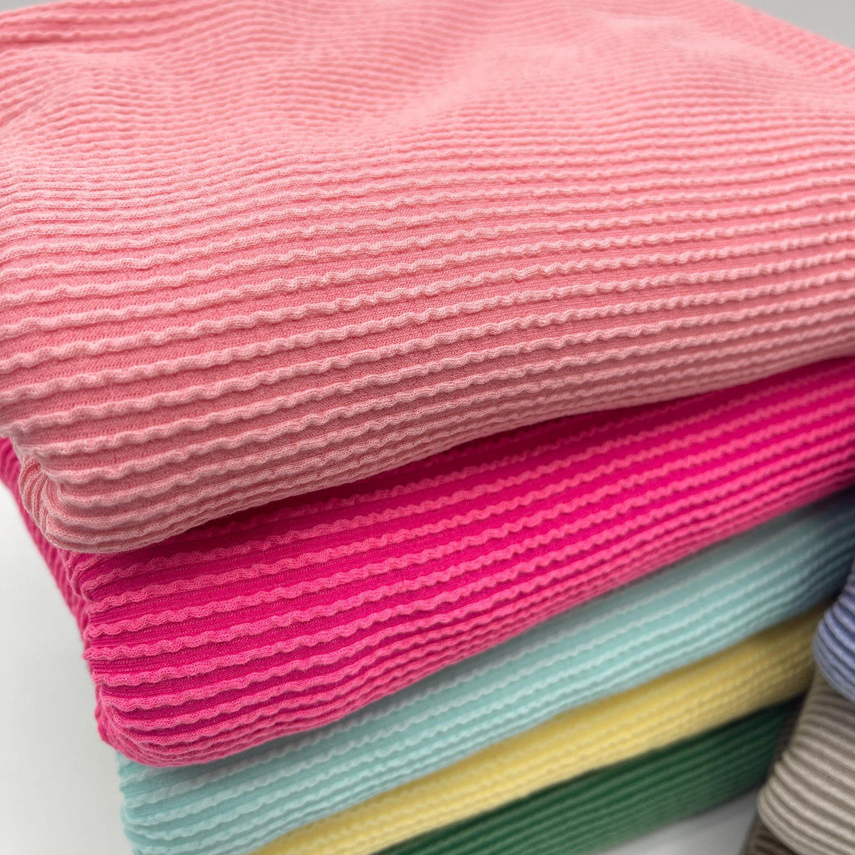 Waved urban rib knit fabric by the yard - peach and fuchsia ribbed knit texture close-up